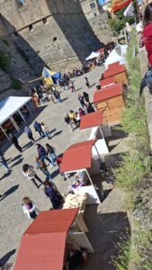 Fila di casette in legno modello 3x2 metri posizionate all'aperto lungo la passeggiata del borgo antico di Termoli, nei pressi del celebre Castello Svevo.