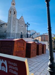 Chioschi in legno scuro a noleggio per mercatini nella piazza della cattedrale di Bovino.