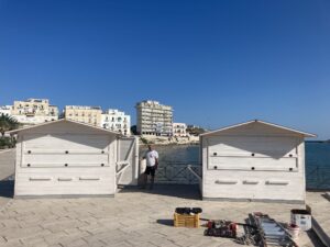 Chioschi in legno bianchi a noleggio per mercatini ed eventi sul lungomare di Rodi Garganico.