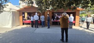 Grande chiosco in legno adibito a cucina all'aperto e show cooking con chef durante un evento.